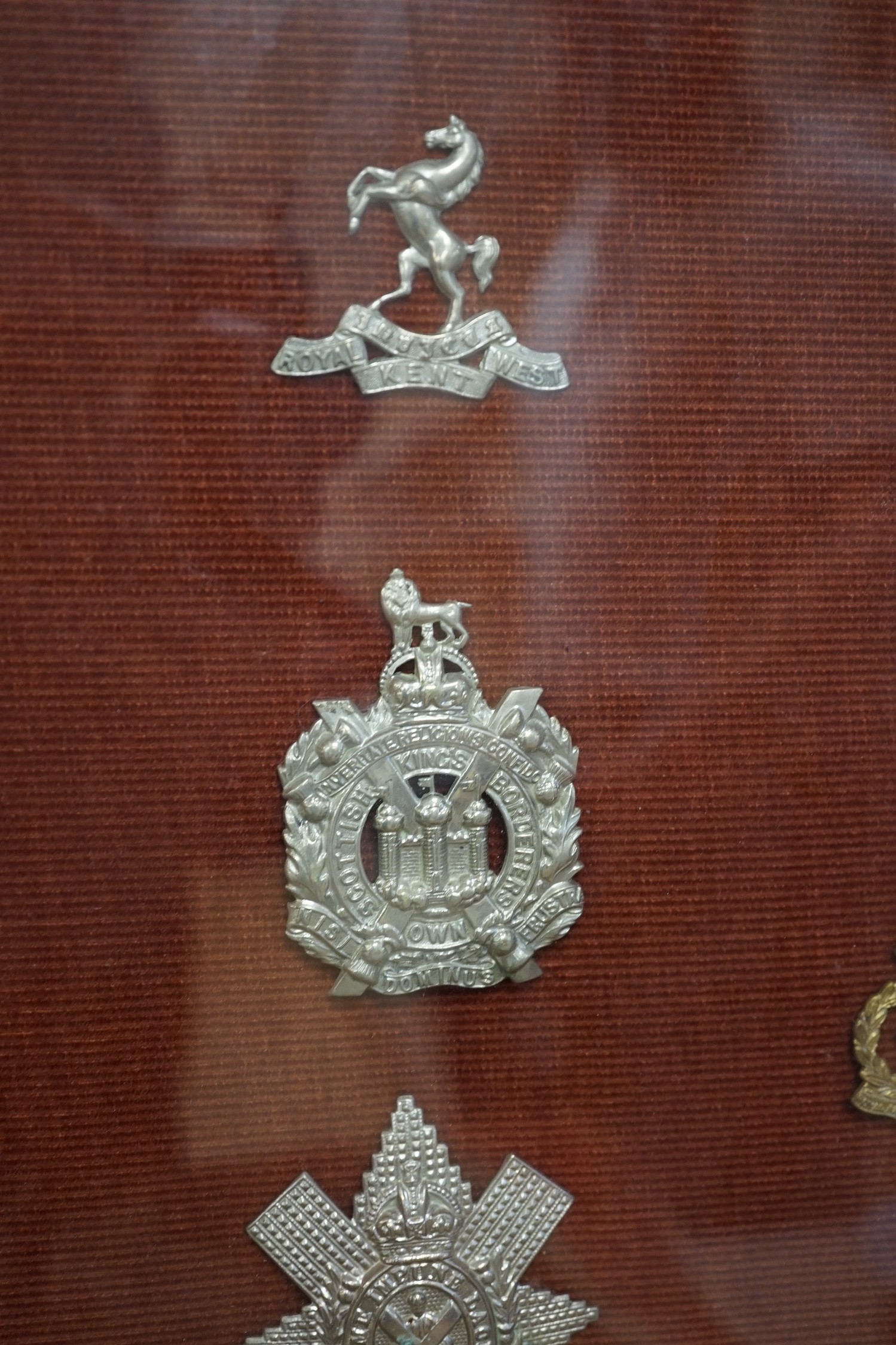 A framed collection of military cap Badges